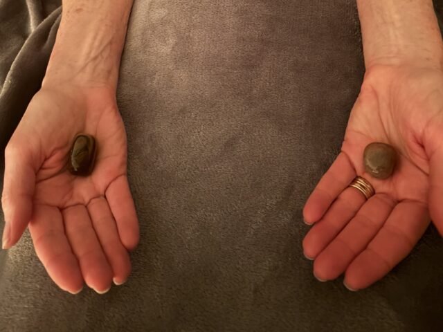 A person resting with crystals placed on the body and in the palms to support chakra balance and energy alignment.