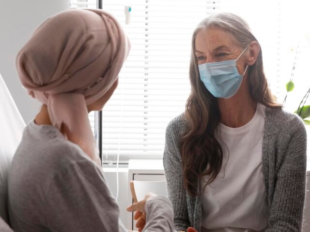A practitioner offering calm, supportive communication with a client during cancer treatment, reflecting compassionate care and clear boundaries.